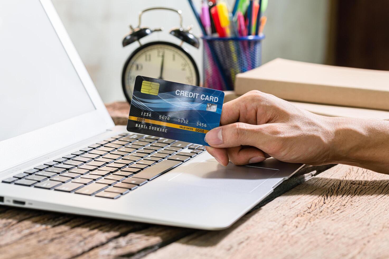 Person using a credit card to shop online through computer photo