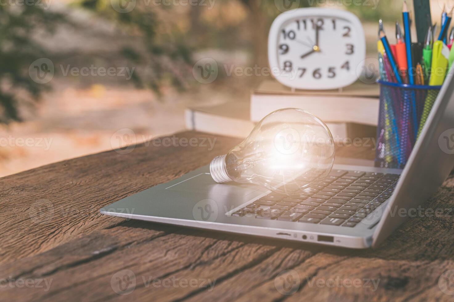 A laptop with a light bulb on top of it photo
