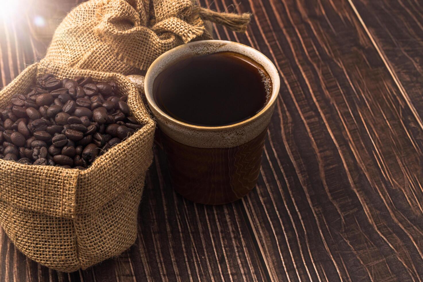 taza de café y granos de café en la mesa foto