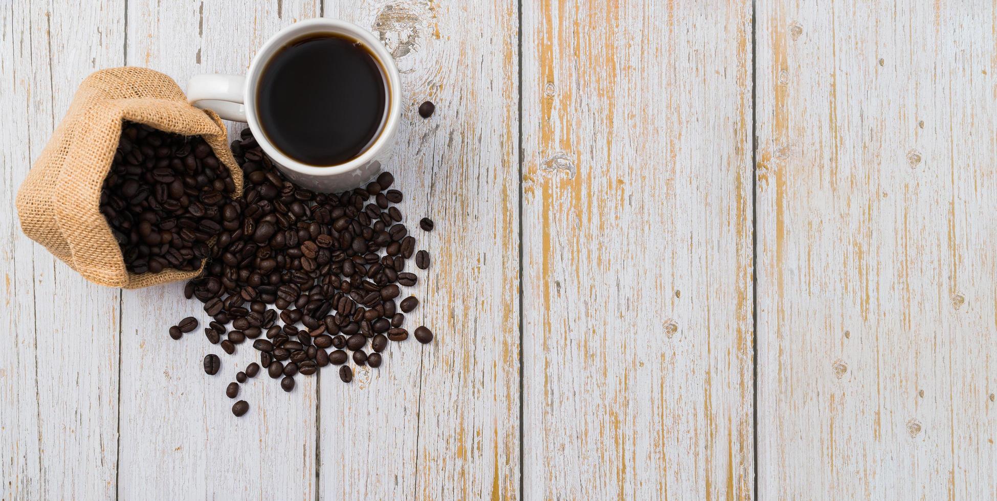 taza de café y granos de café en la mesa foto