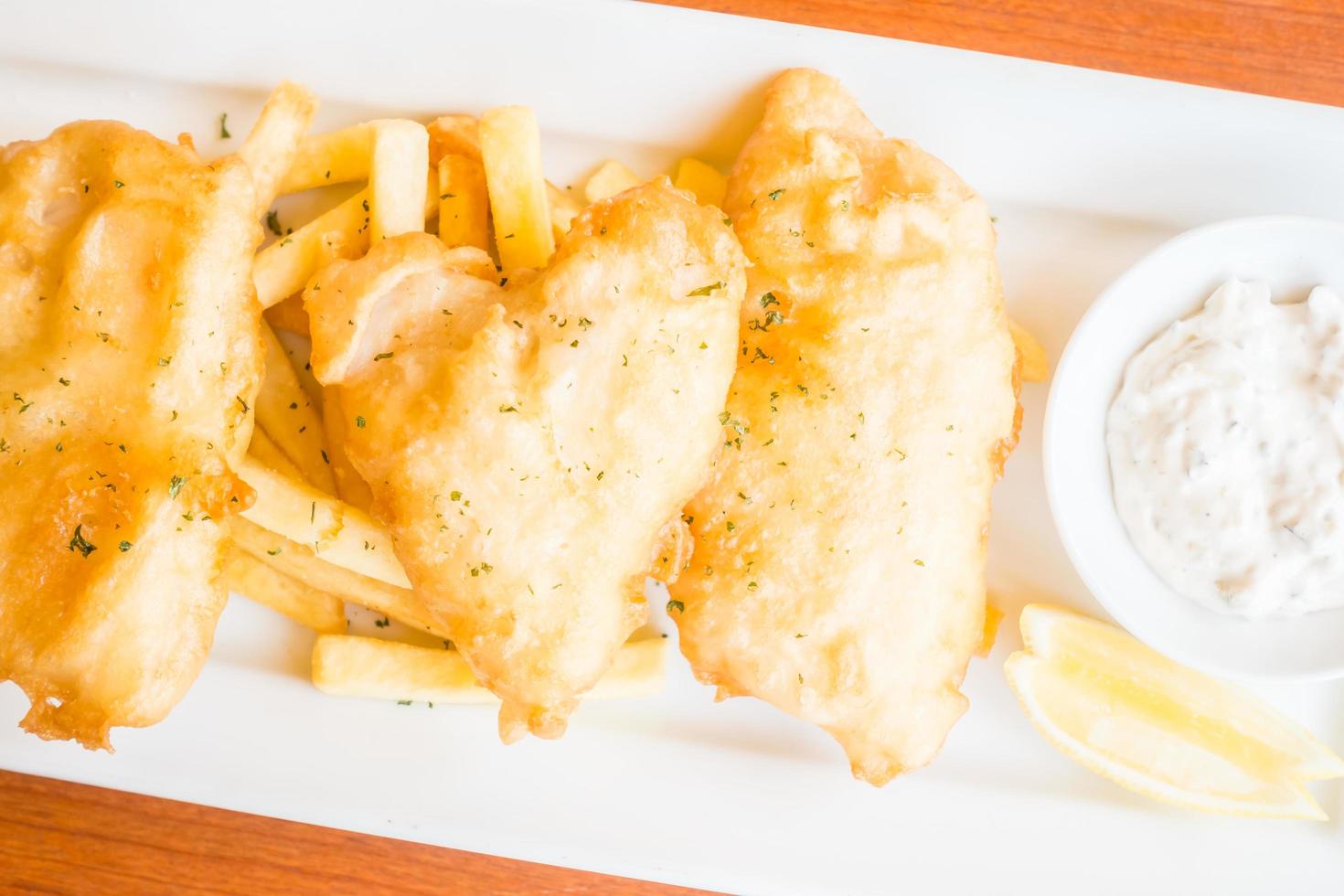 pescado y patatas fritas en un plato blanco foto