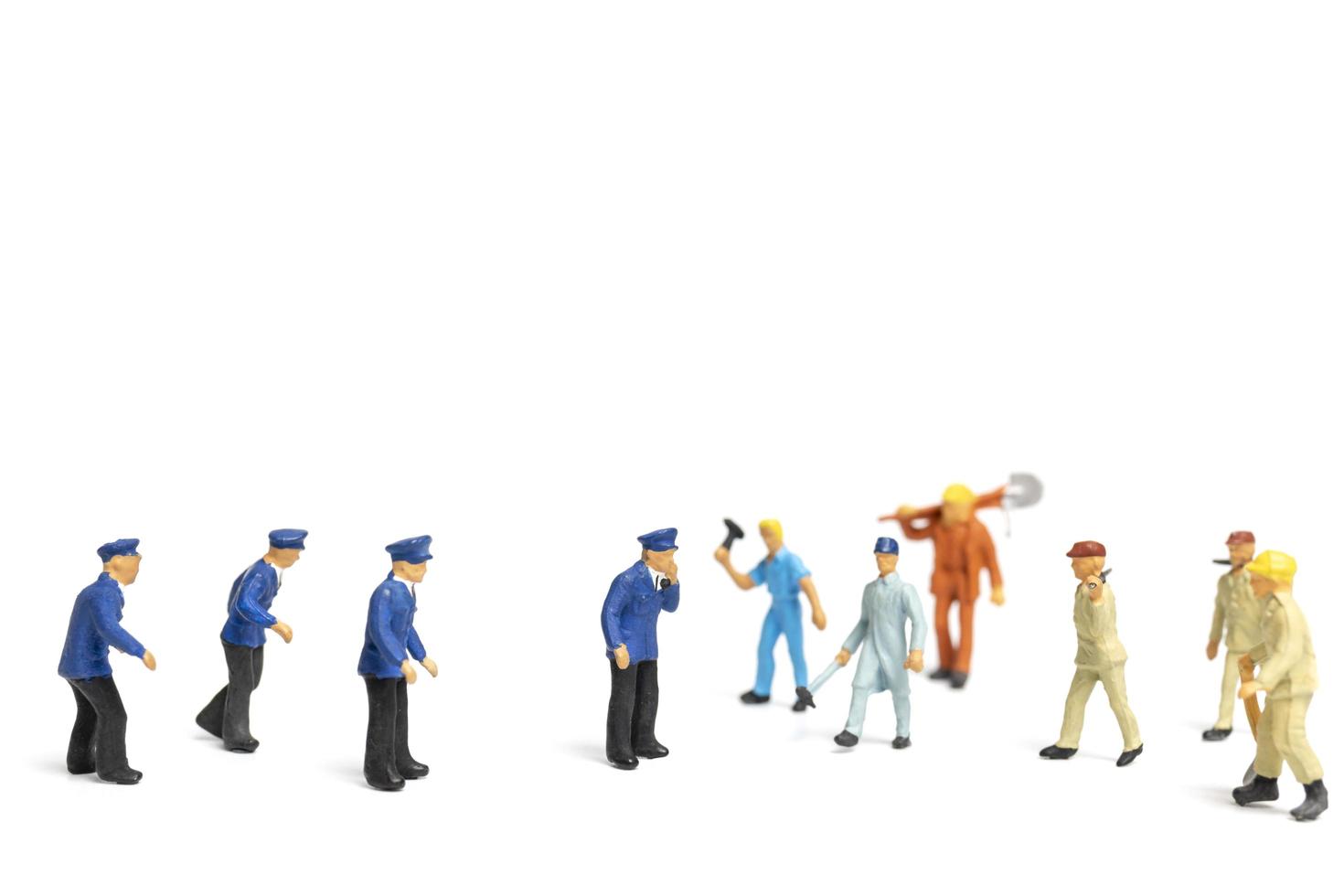 Miniature police and an angry mob on a white background photo