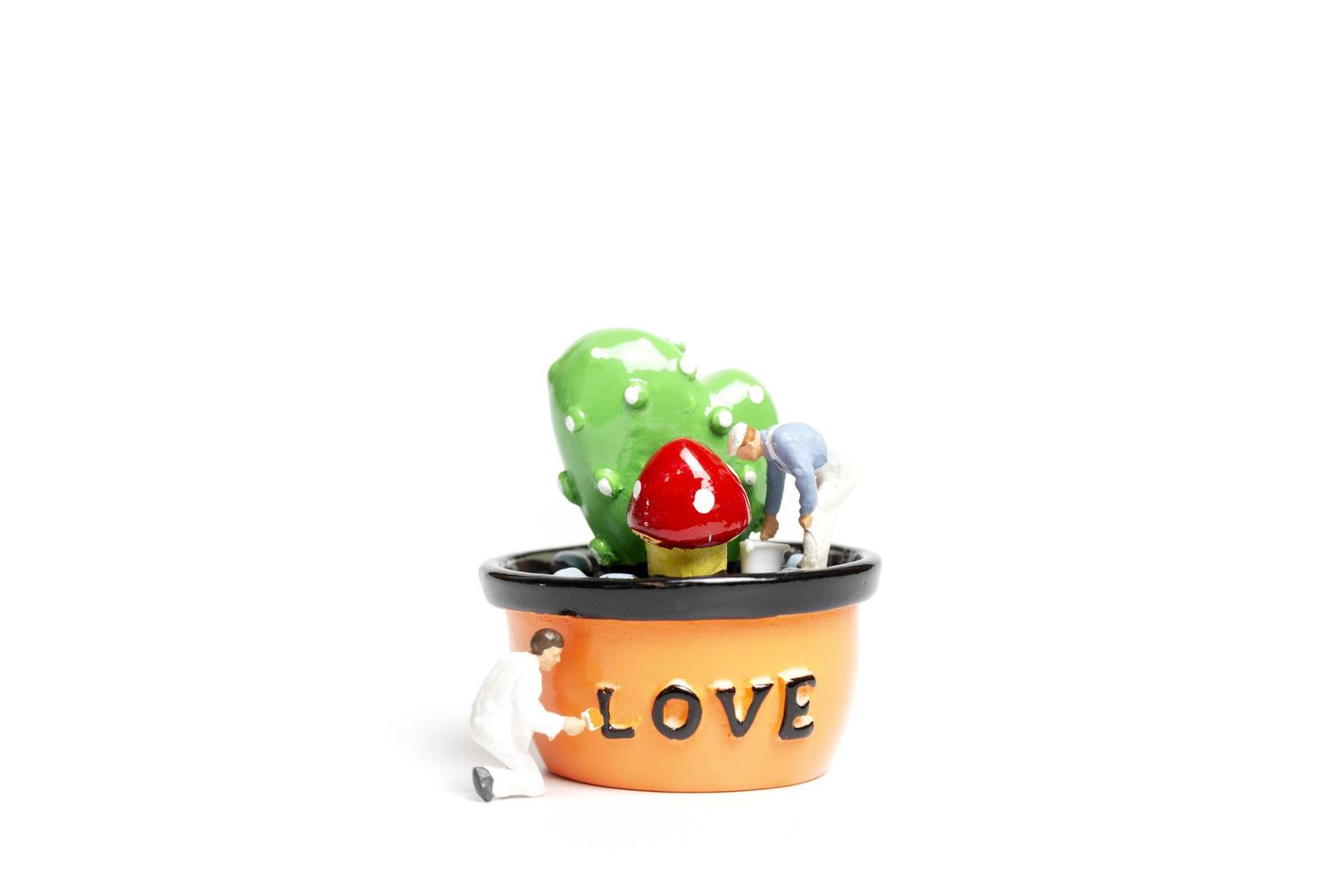 Miniature painters coloring plants in a pod with the word love, Valentine's Day concept photo