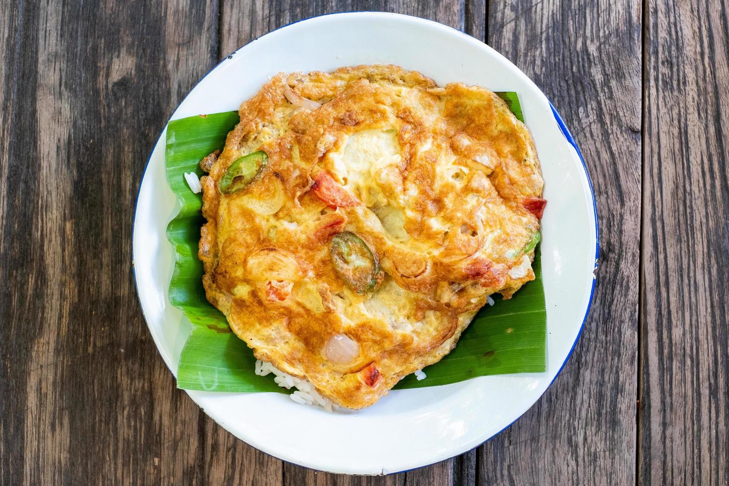 Omelet with onions, tomatoes, eggplant shot from above on a rustic wooden texture photo