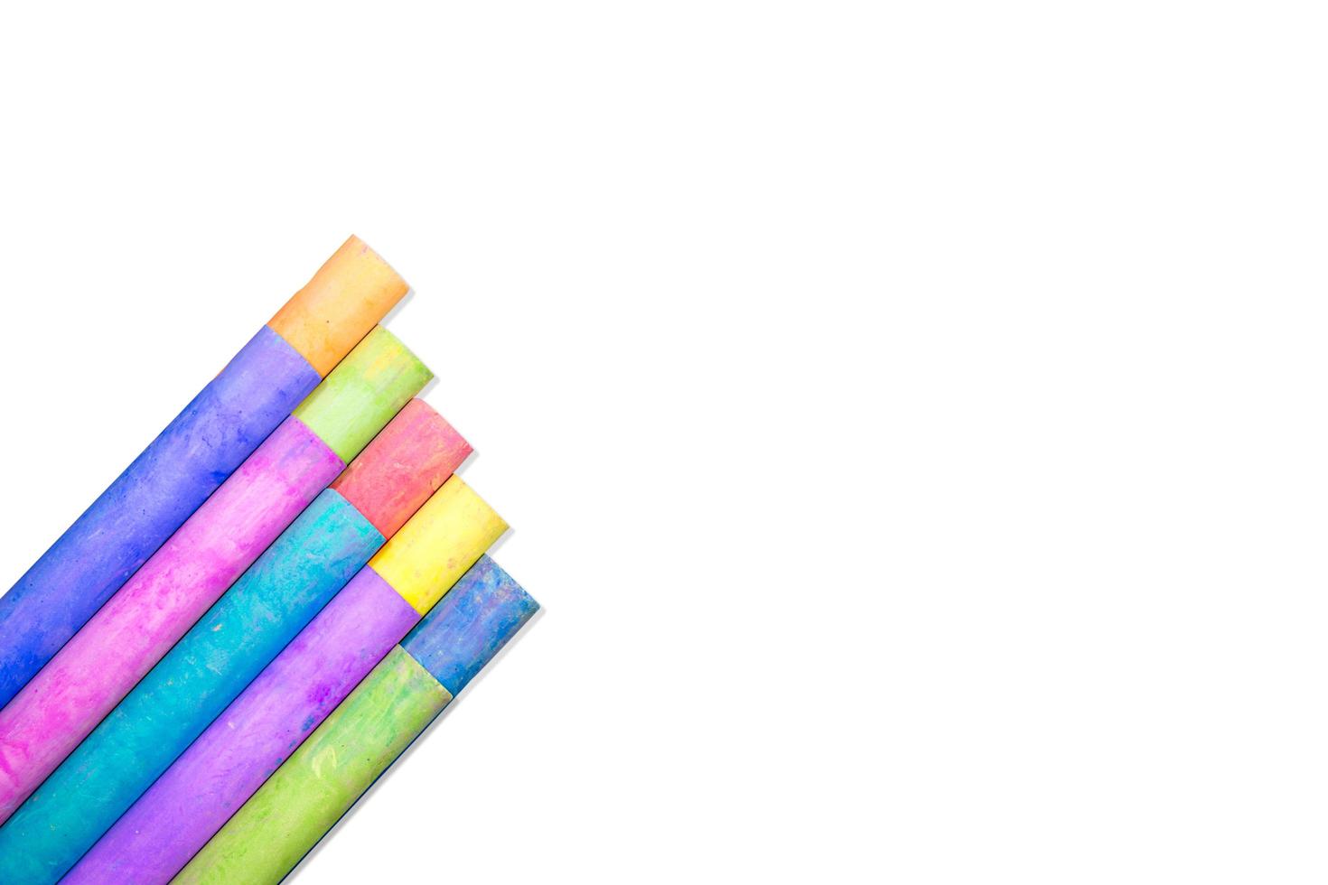 Rows of rainbow-colored chalk isolate on white background photo