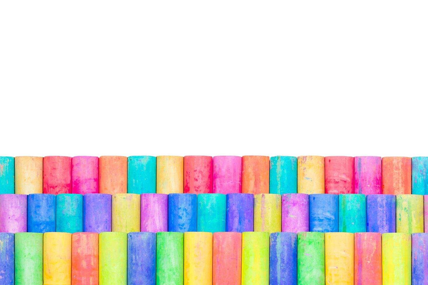 Rows of rainbow-colored chalk isolated on a white background photo