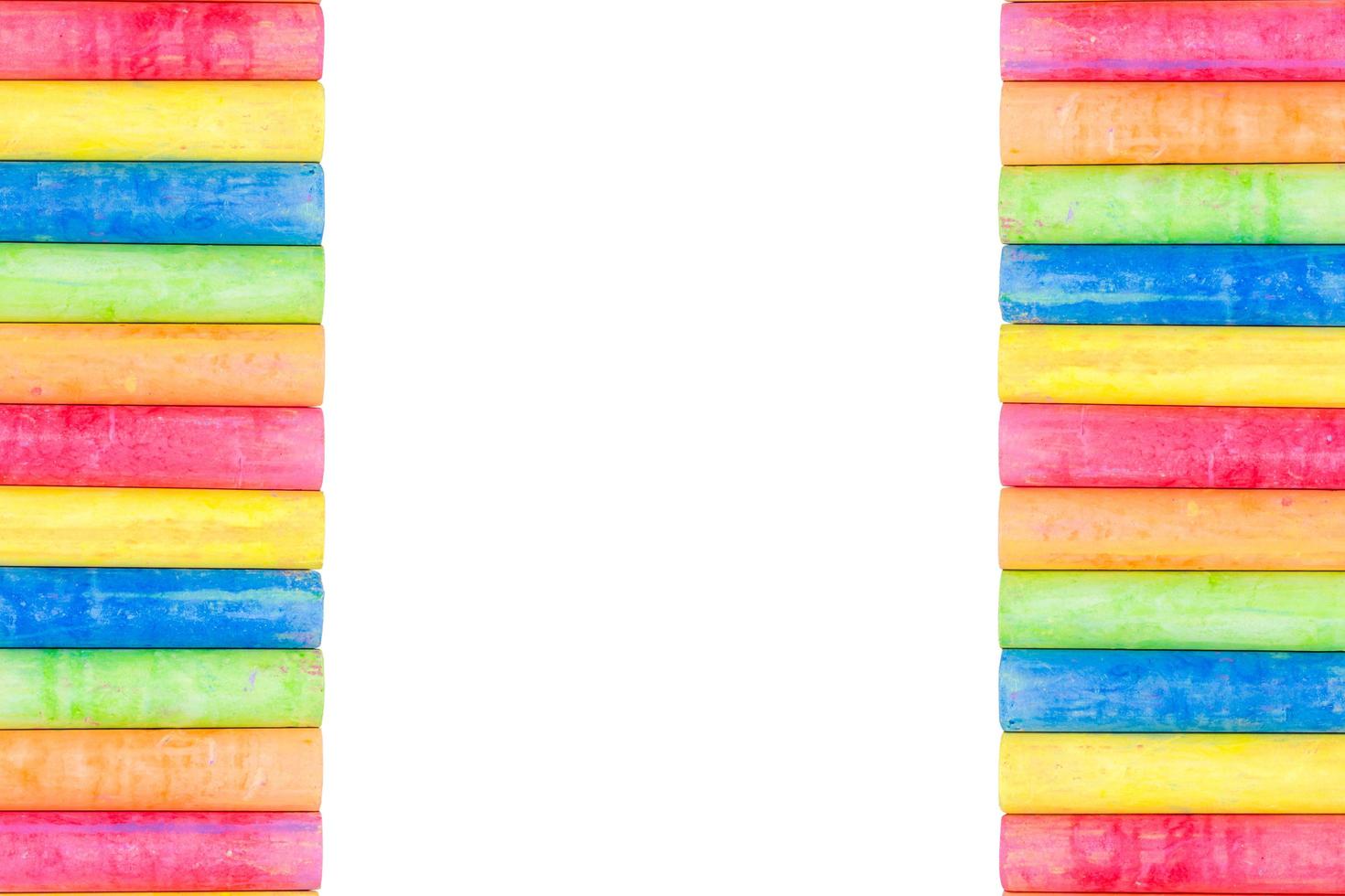 Rows of rainbow-colored chalk isolated on a white background photo