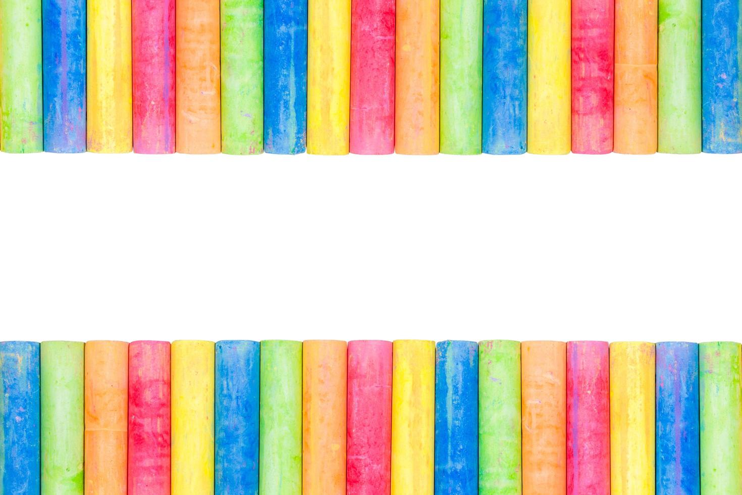Rows of rainbow-colored chalk isolated on a white background photo