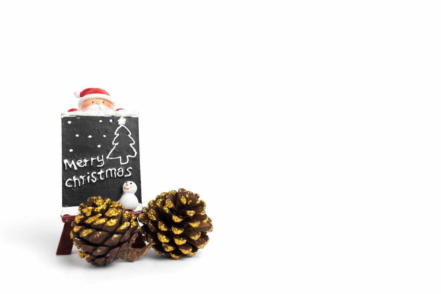 Santa Claus figurine with a miniature chalkboard with Merry Christmas text on a white background photo