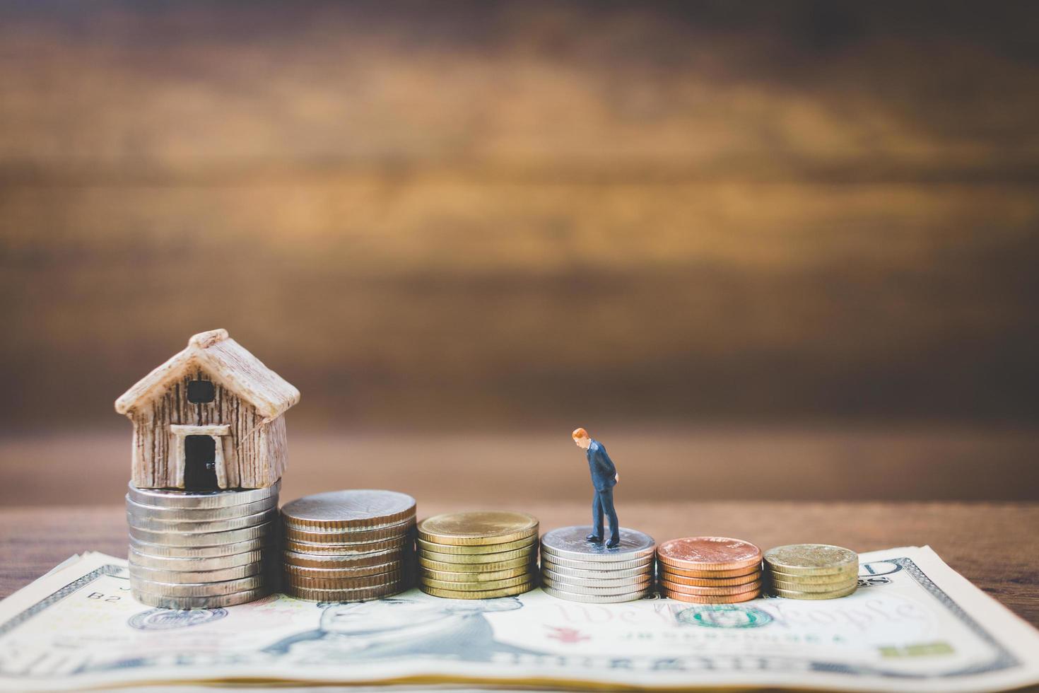 Miniature businessmen on money on a wooden background photo