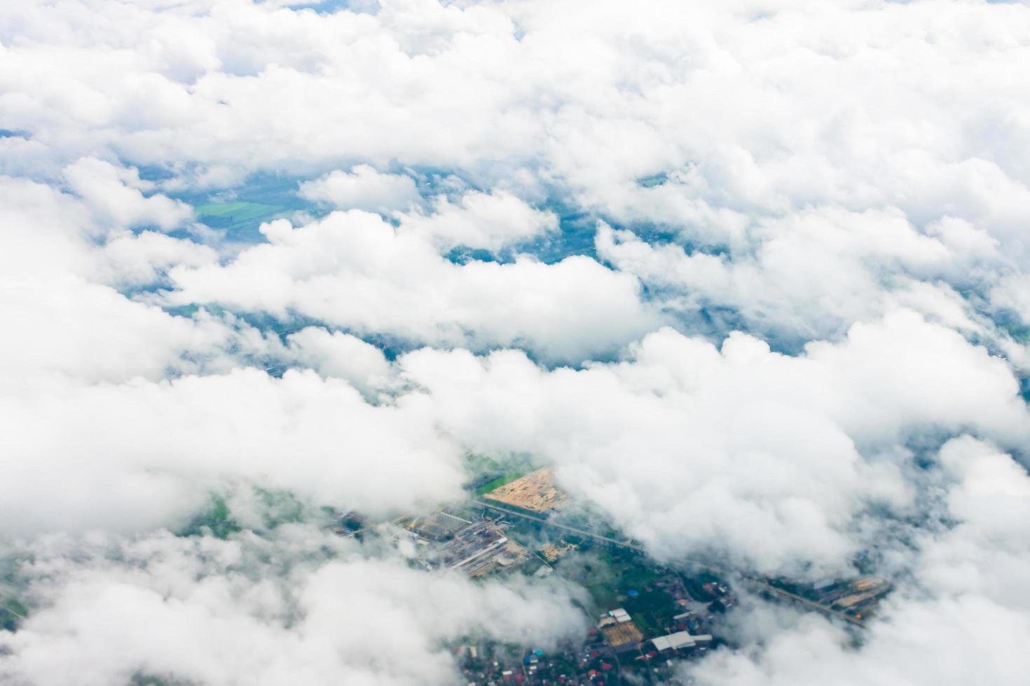 Top view from an airplane showing white clouds and the Earth below photo