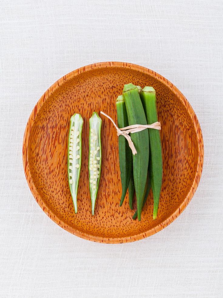 okra fresca en una placa de madera foto