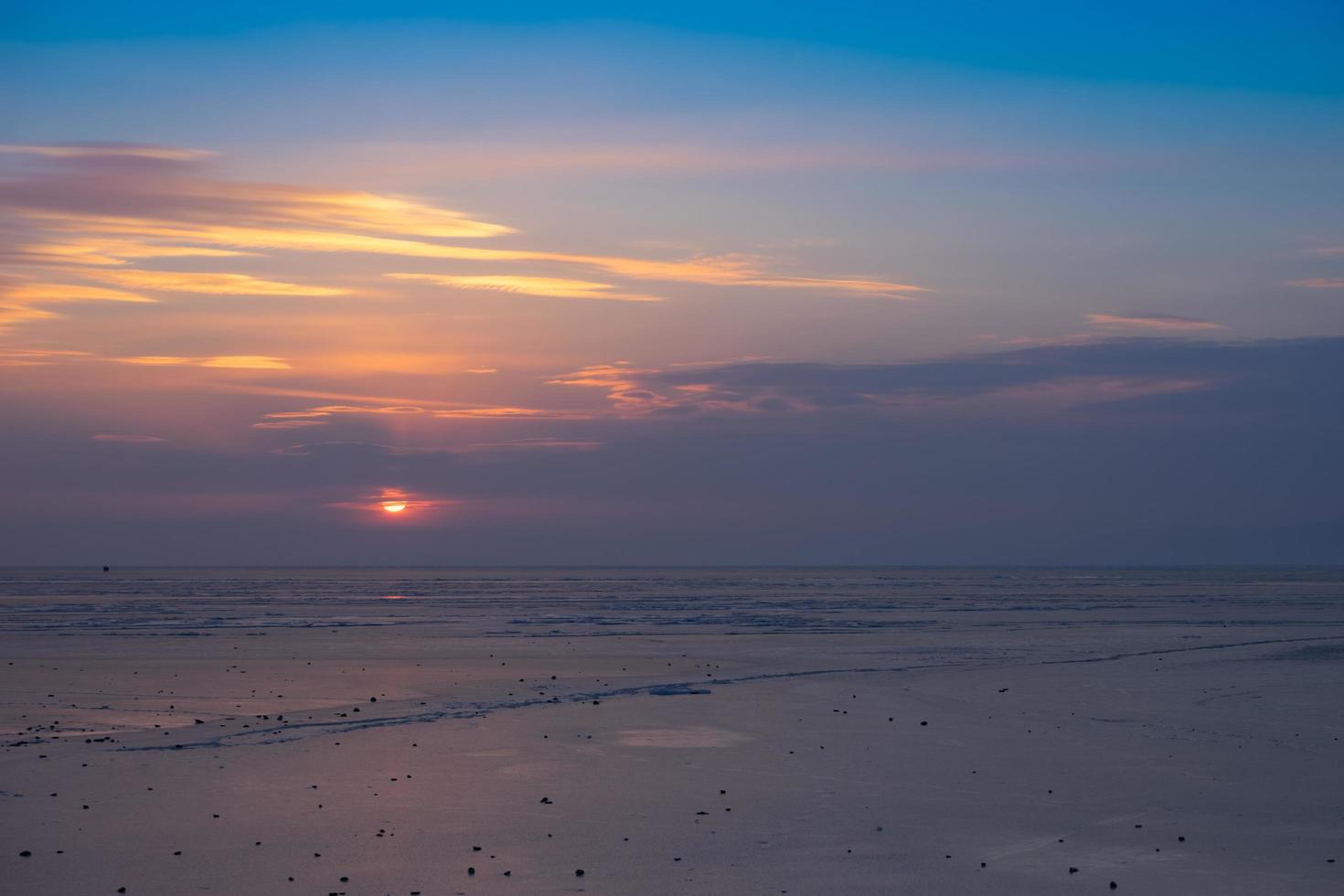 Colorido atardecer nublado sobre una playa en la bahía de Amur en Vladivostok, Rusia foto