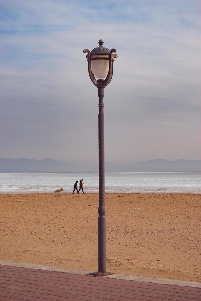 Paisaje con farola en una playa con un nublado cielo azul en Vladivostok, Rusia foto