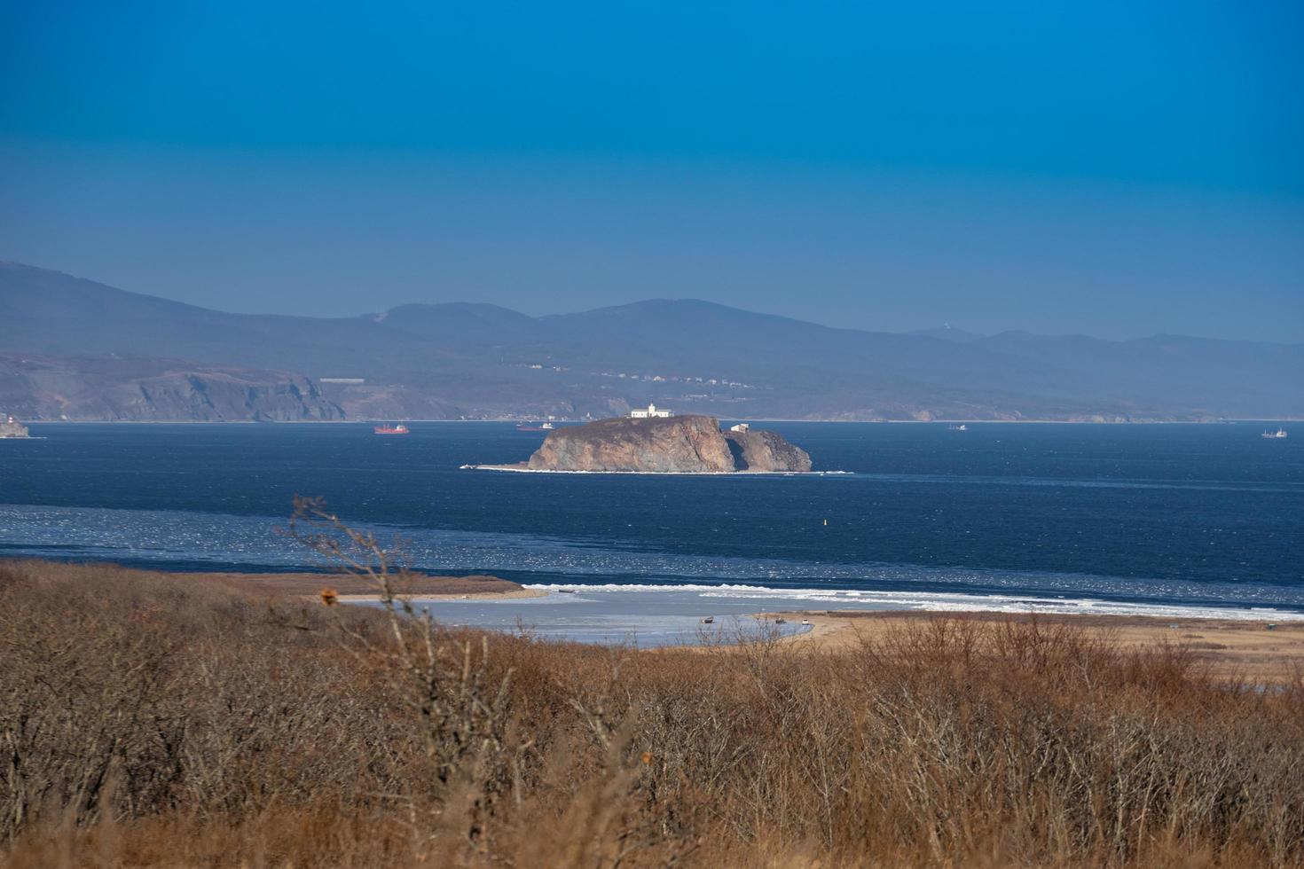 Seascape of an island in a body of water with coastline in Vladivostok, Russia photo
