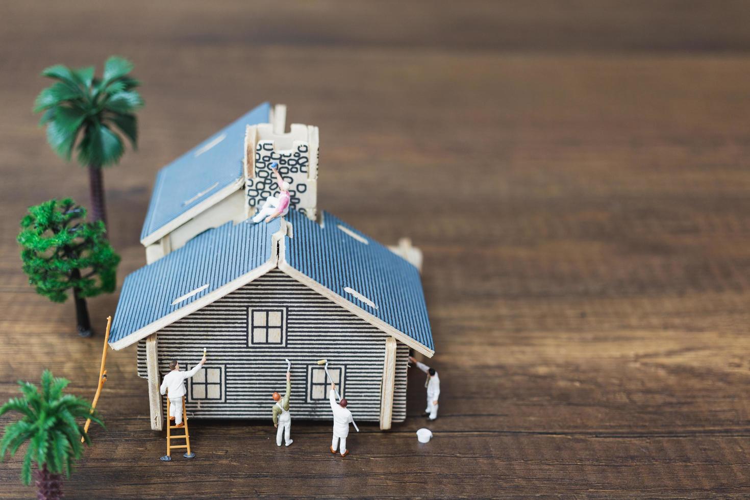 Miniature workers painting a new home, renovation concept photo