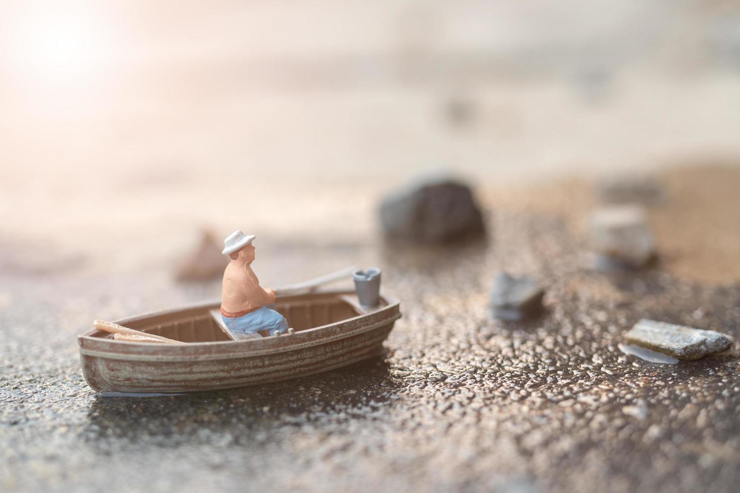 Pescador en miniatura pescando en un barco foto
