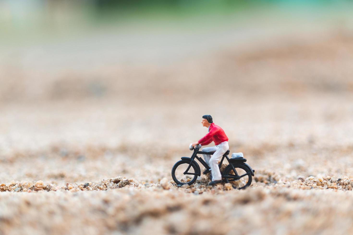 Miniature traveler riding a bicycle, exploring the world concept photo