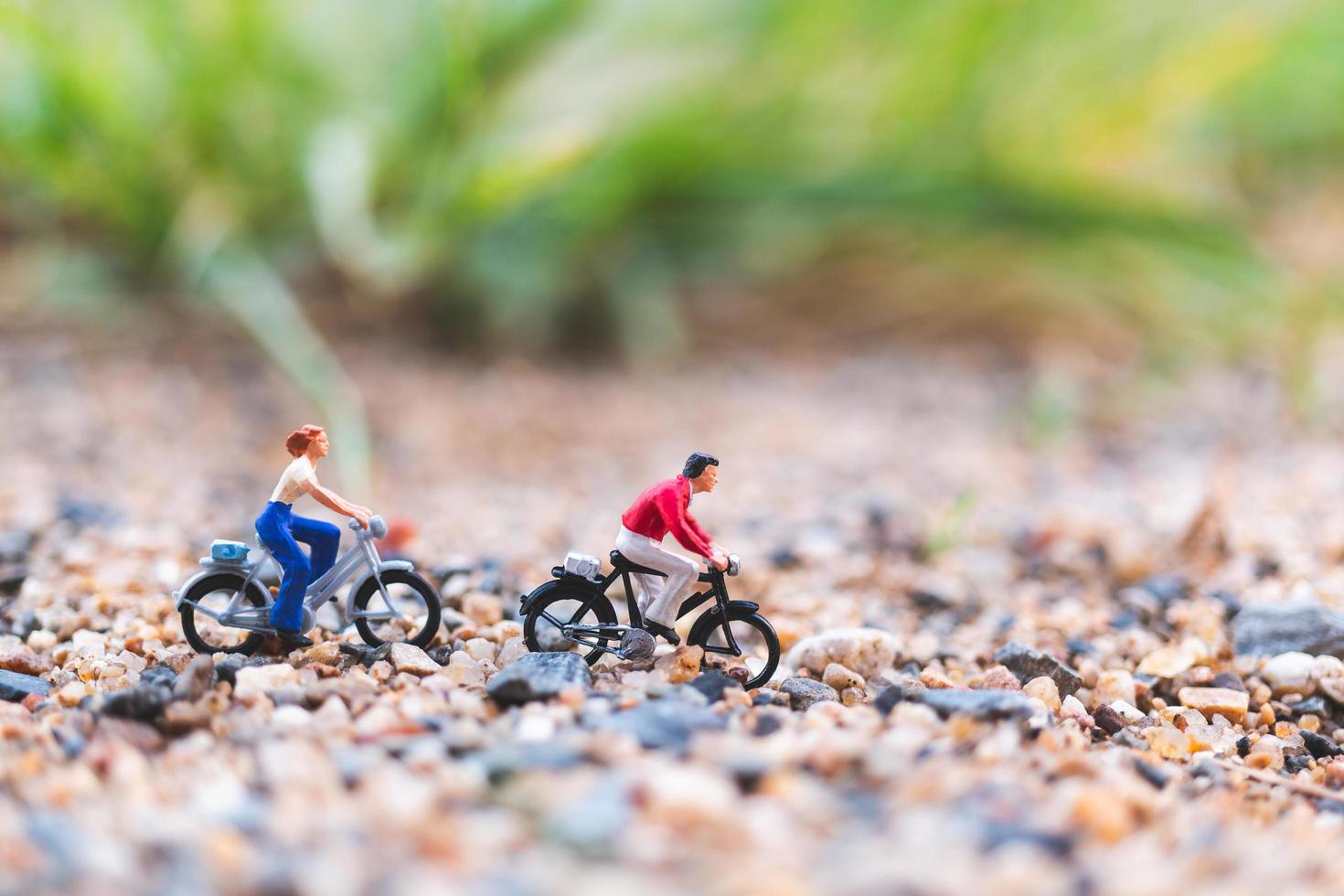 Viajeros en miniatura en bicicleta, explorando el concepto del mundo. foto