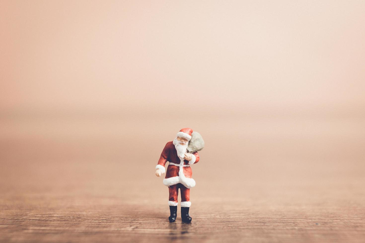 Santa Claus en miniatura con una bolsa, concepto de celebración de Navidad foto