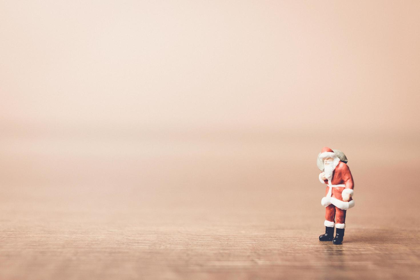 Miniature Santa Claus carrying a bag, Christmas celebration concept photo