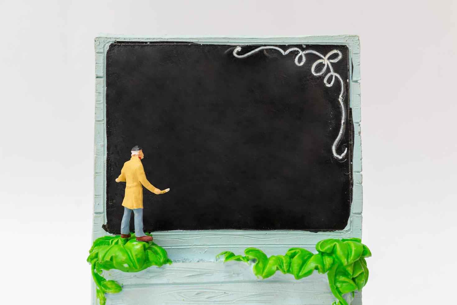 Miniature painter holding a brush on a chalkboard photo