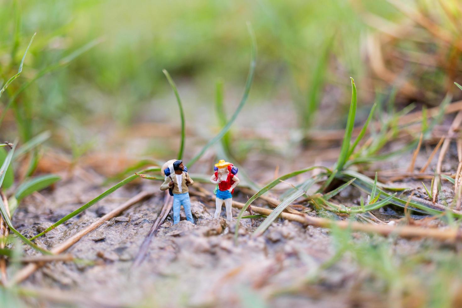 Viajero en miniatura con mochilas caminando en el campo, concepto de viaje y aventura foto