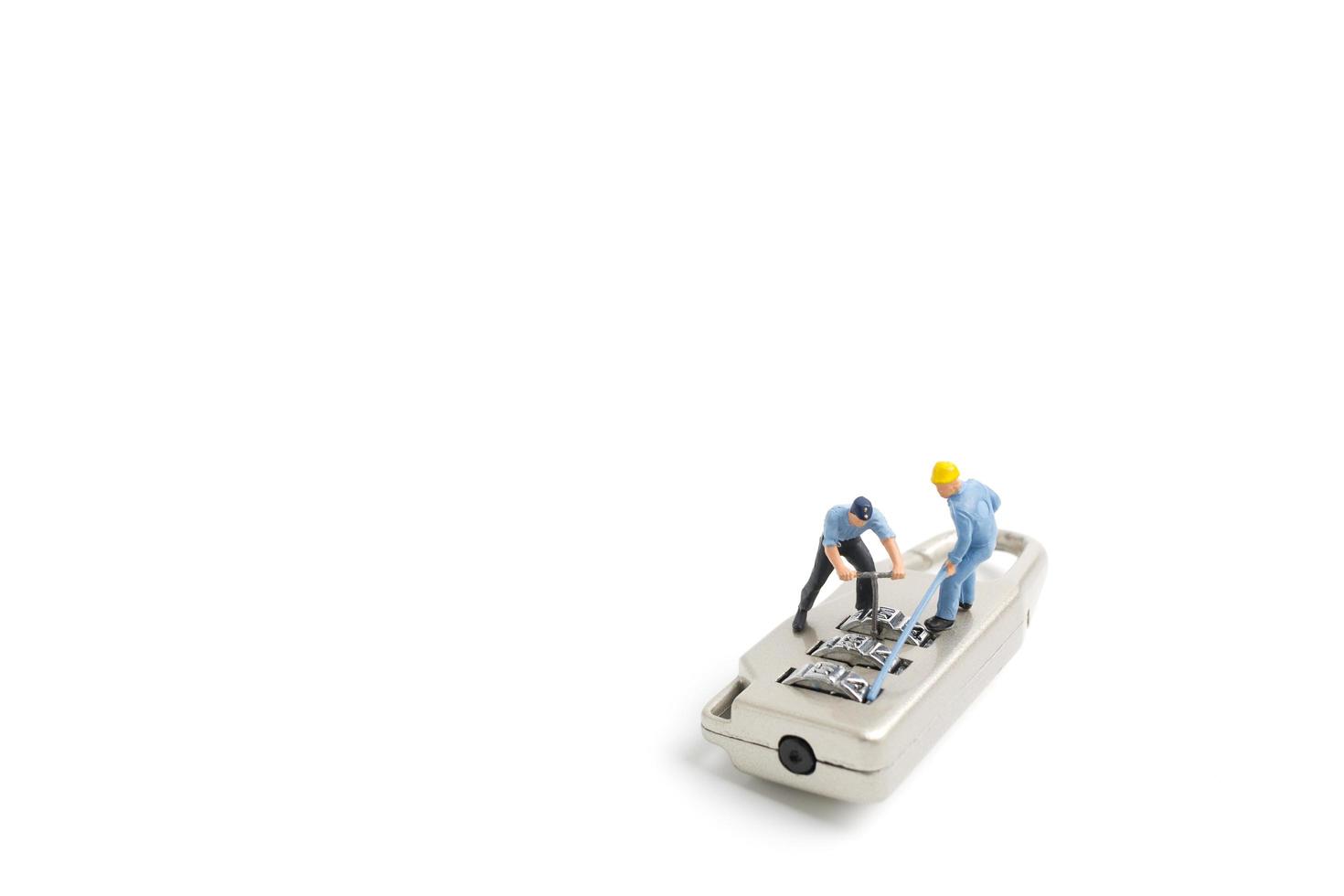 Miniature workers unlocking the password on a lock, teamwork concept photo