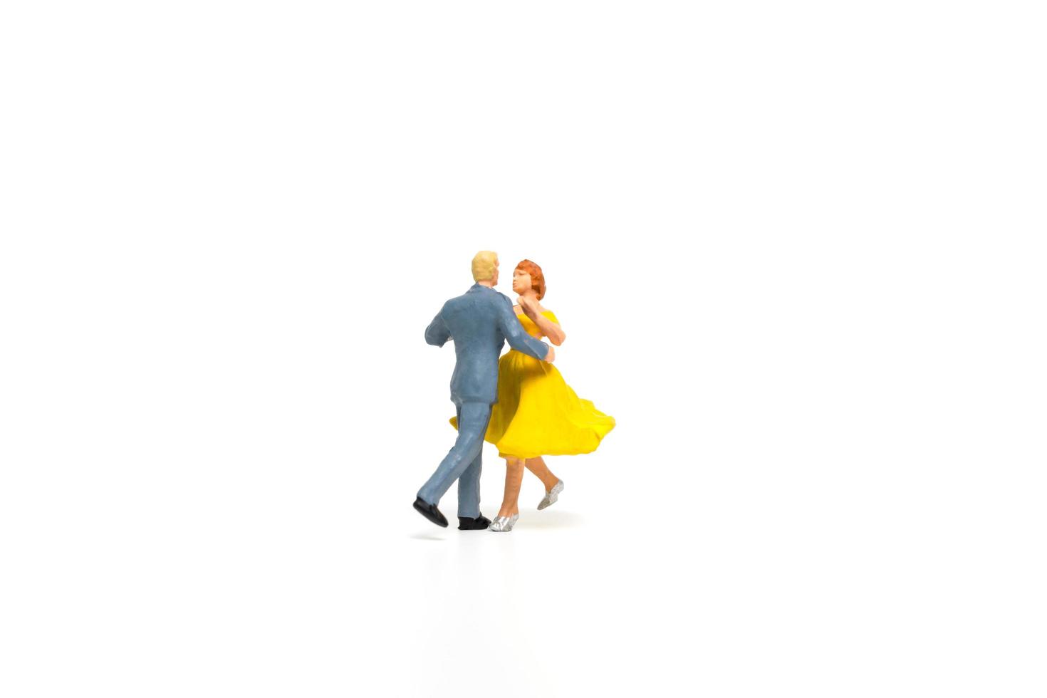 Miniature couple dancing romantically on a white background, Valentine's Day concept photo