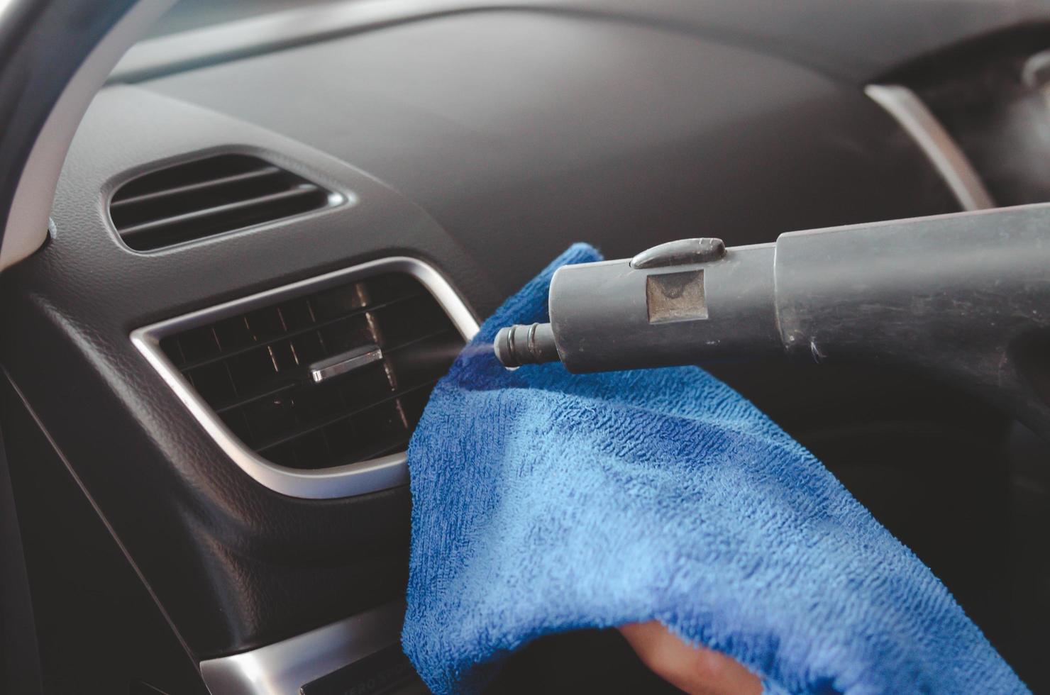 Person steam cleaning a car photo