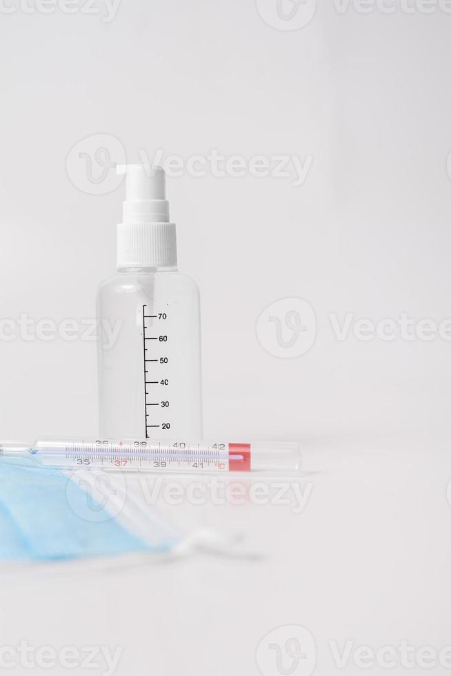 mascarilla quirúrgica con termómetro y gel desinfectante foto