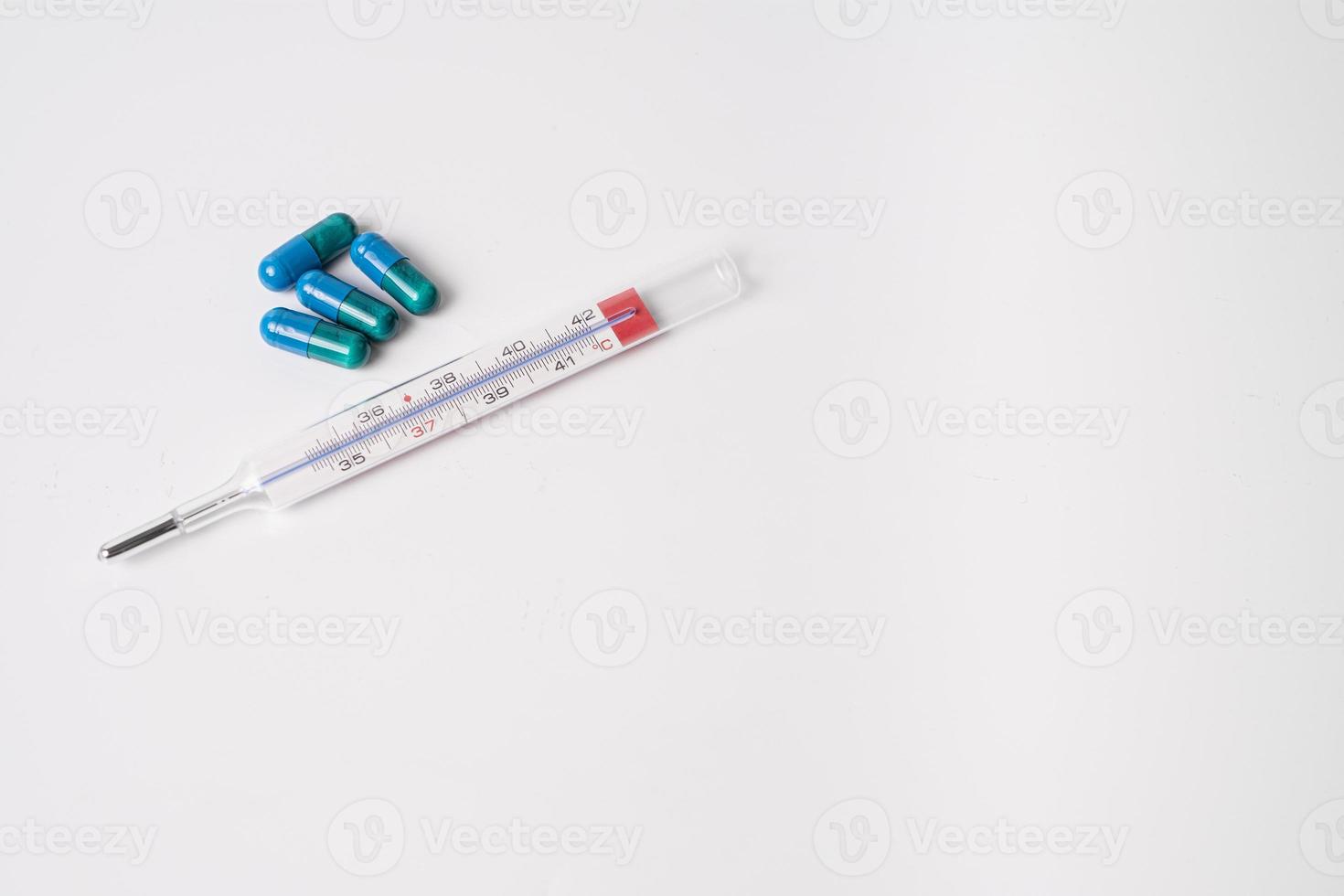 cápsulas medicinales y termómetro foto