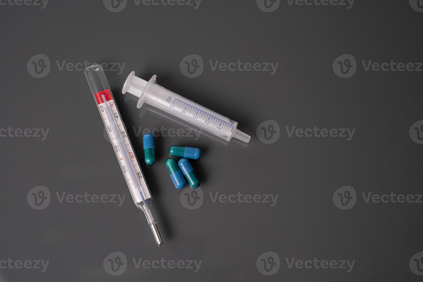 Medicine thermometer and syringe background photo