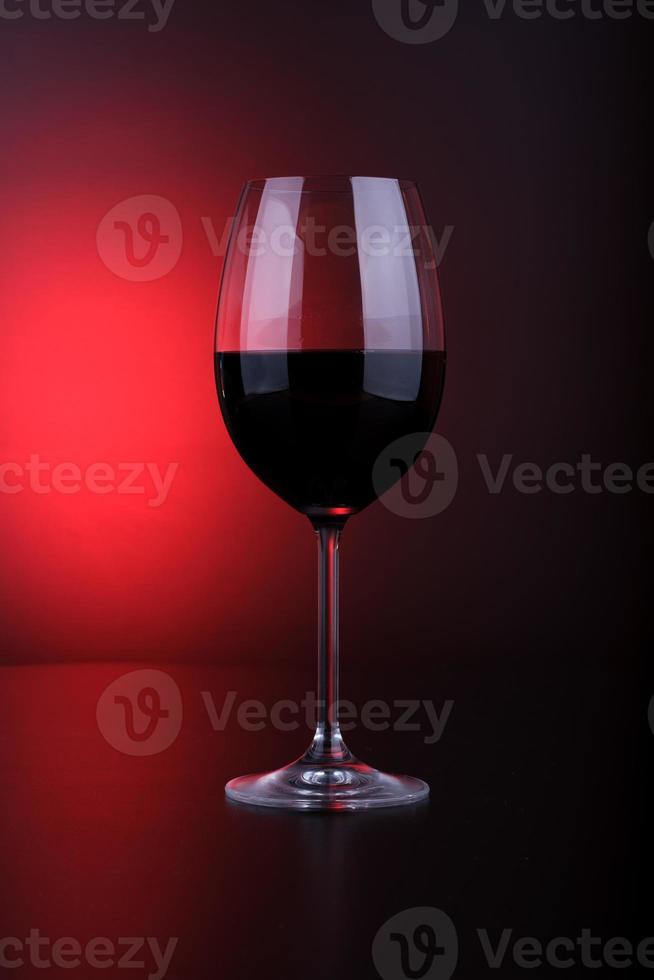 Wine glass filled red and black background photo