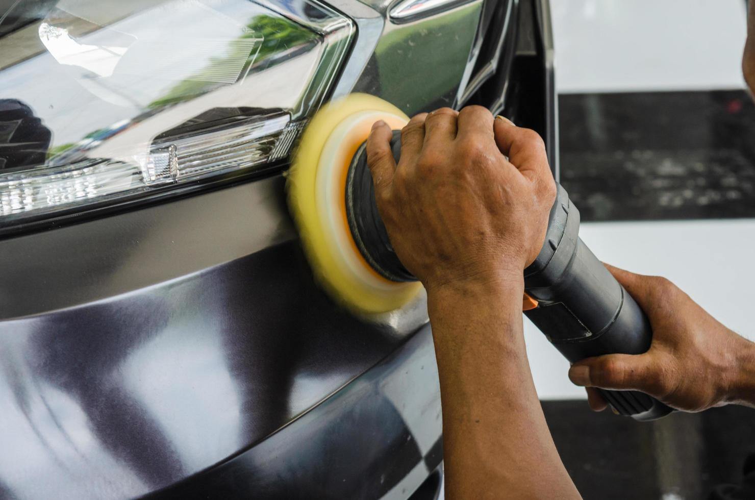 Person polishing a car headlight photo