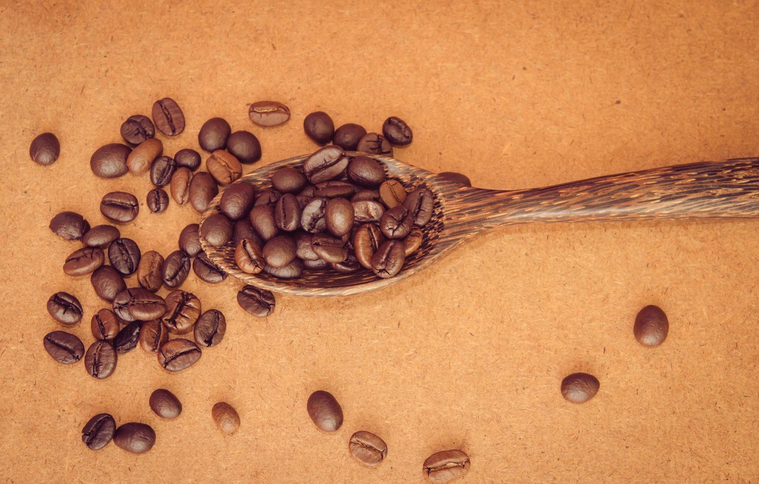 Coffee beans in a wooden spoon photo