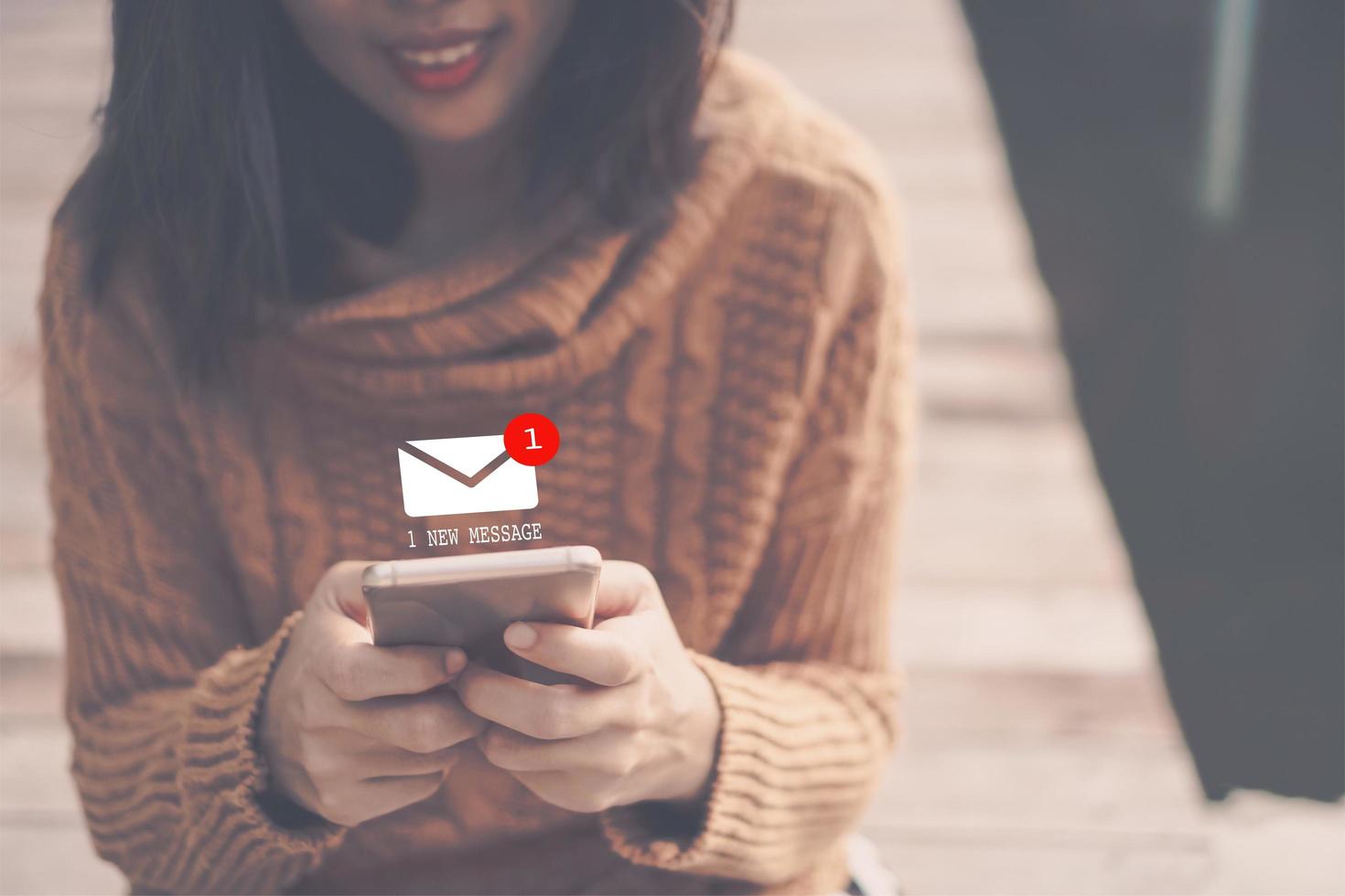 Woman using smartphone to send and receive email photo