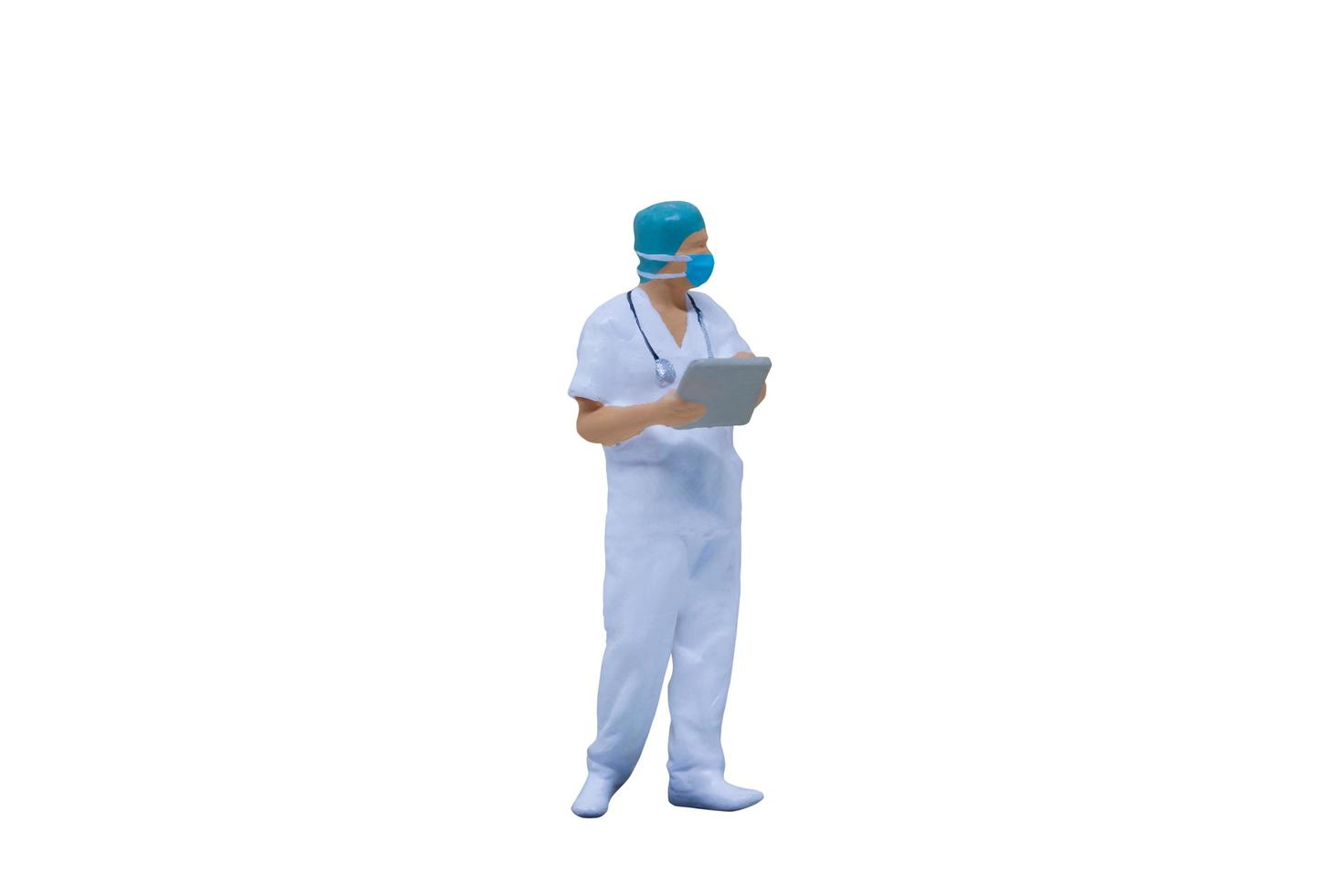 Médicos en miniatura con trajes de protección y máscaras sobre un fondo blanco. foto