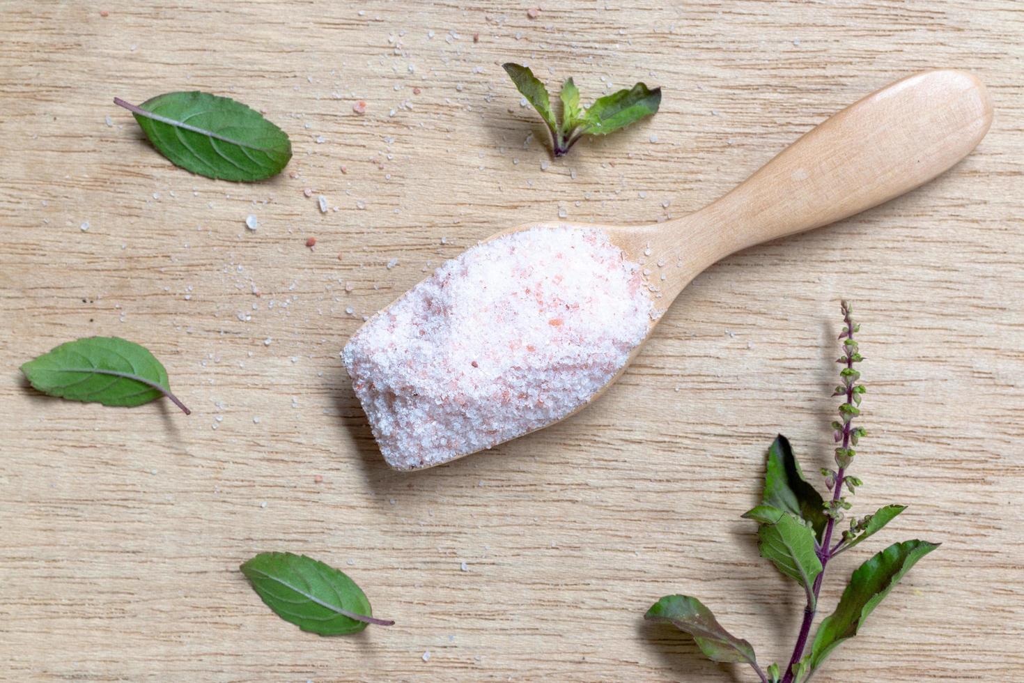 Pink salt Himalayan salt on a wooden background photo