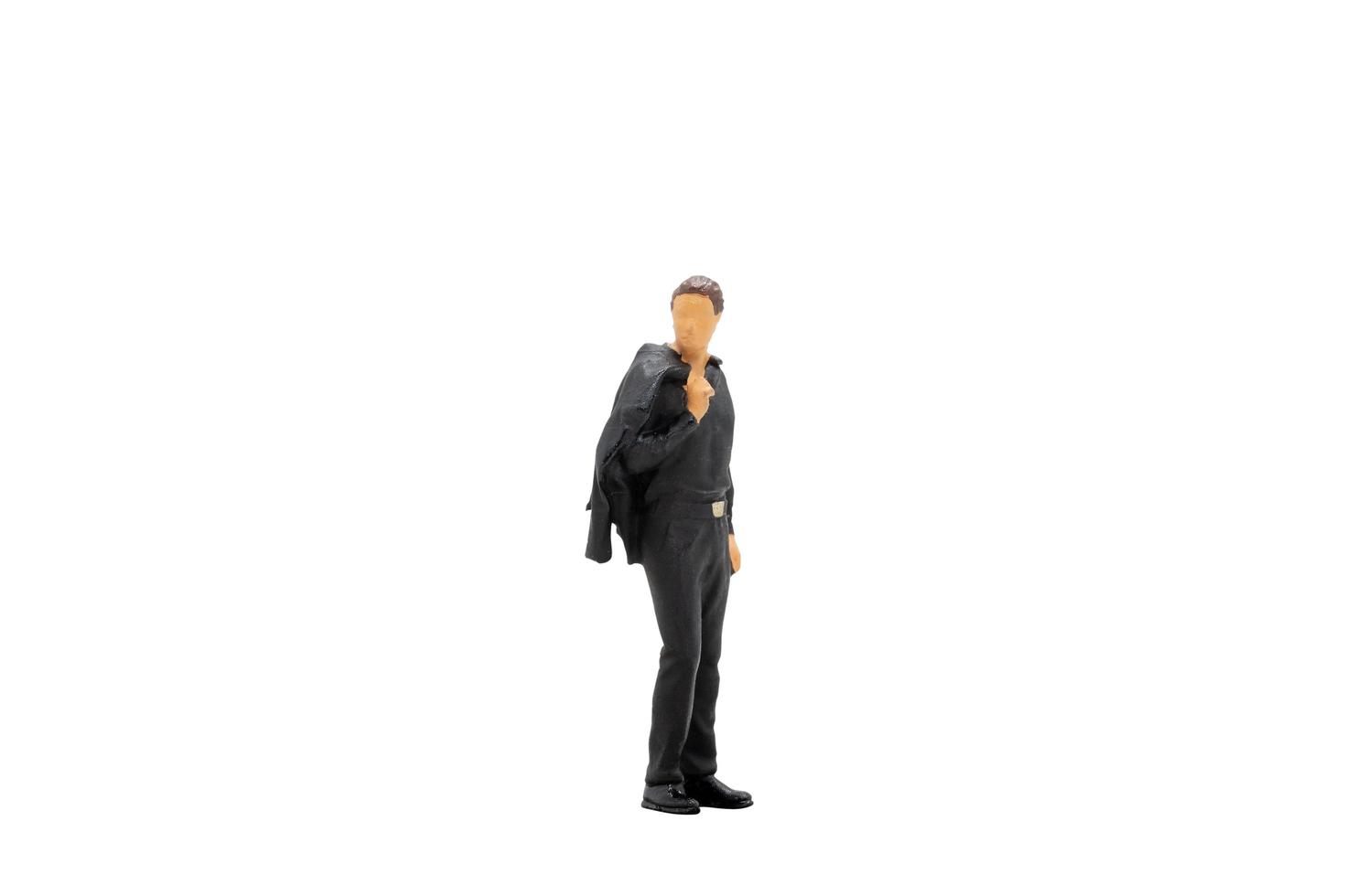 Miniature businessman standing isolated on a white background photo