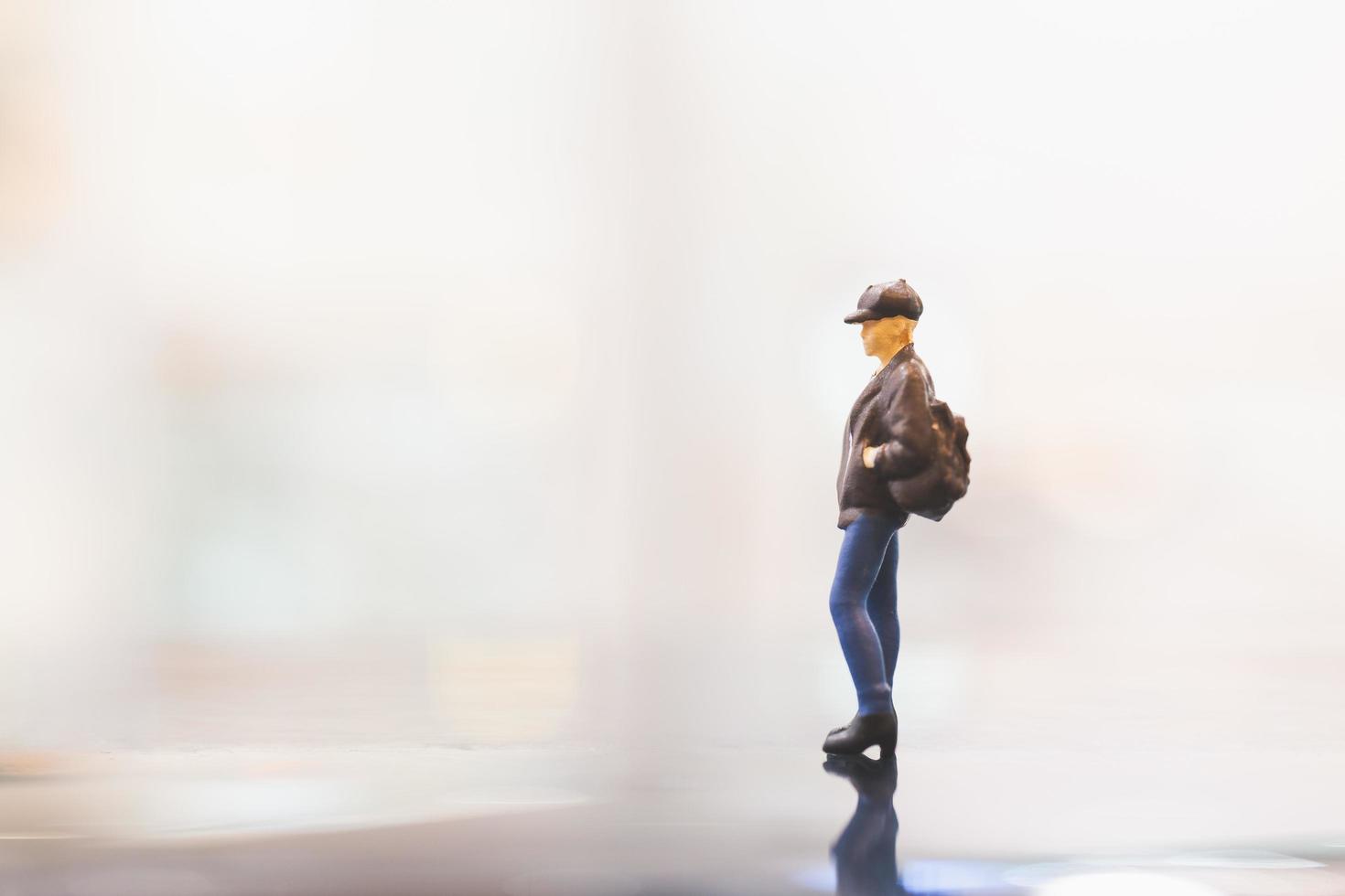 Miniature traveler with a backpack walking on empty space, travel concept photo
