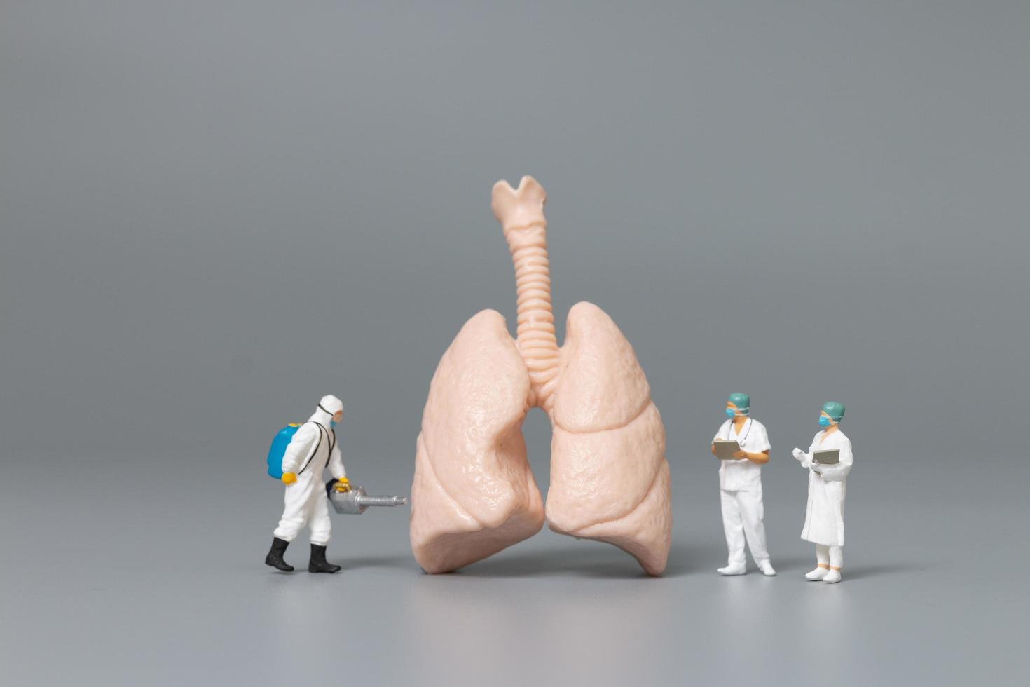 Miniature doctors and nurses observing and discussing the human lung, virus and bacteria-infected concept photo