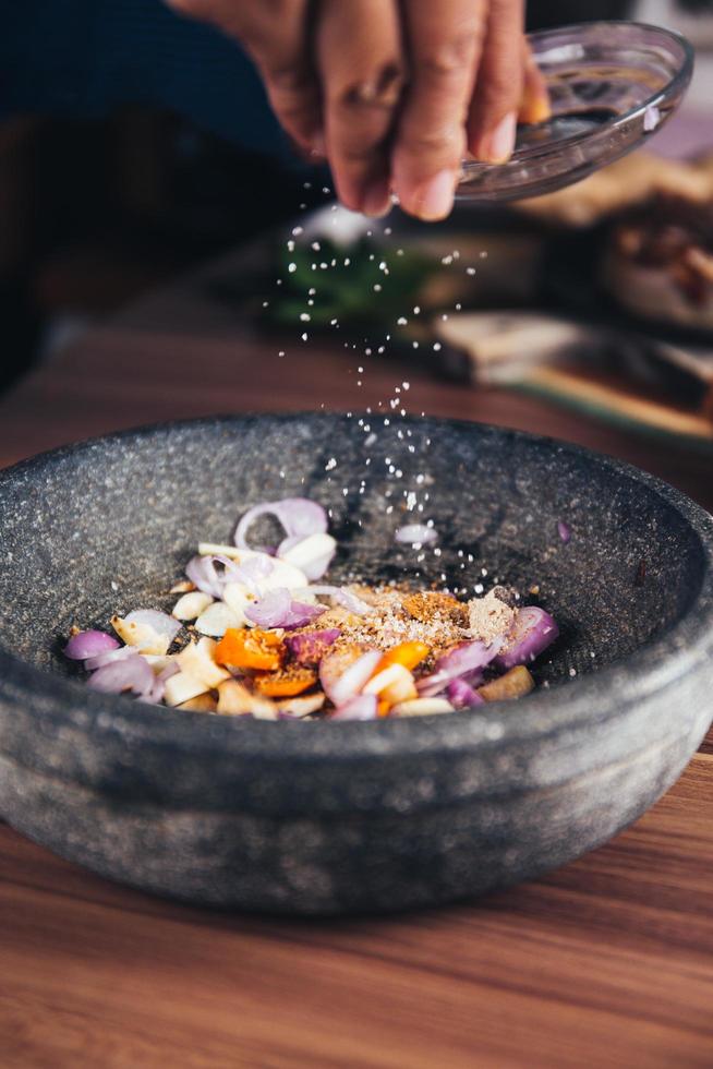 A person pouring salt in a bowl photo