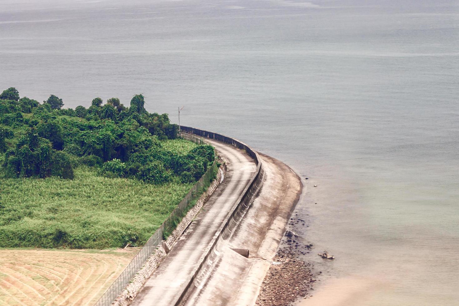 Vista aérea de una carretera de hormigón marrón cerca de un cuerpo de agua foto