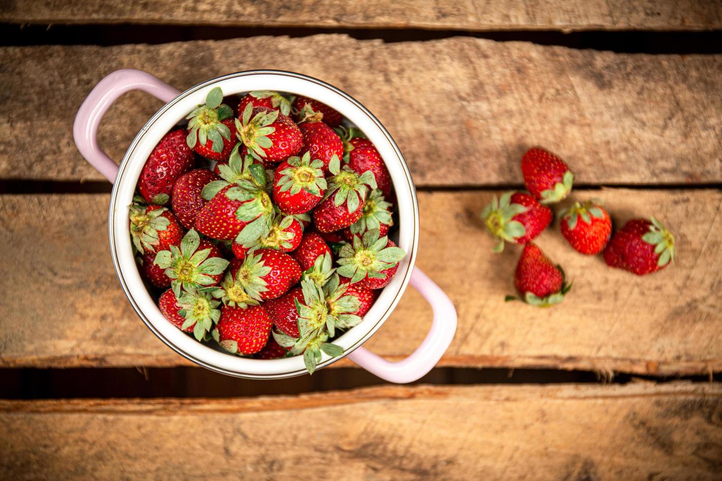 Strawberries in a bucket on a wood table photo