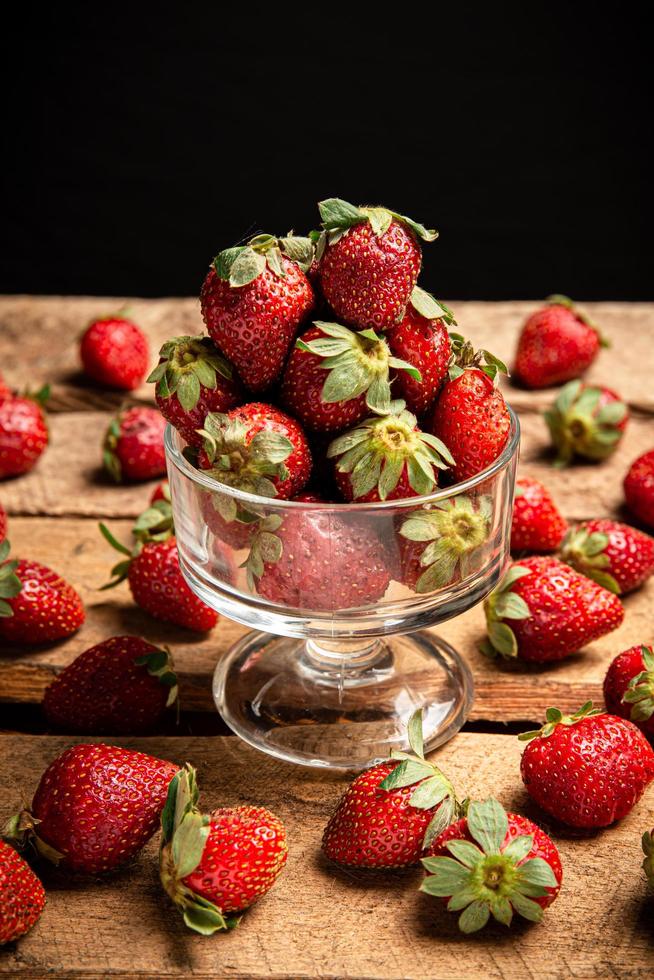 fresas en un vaso y en una mesa foto