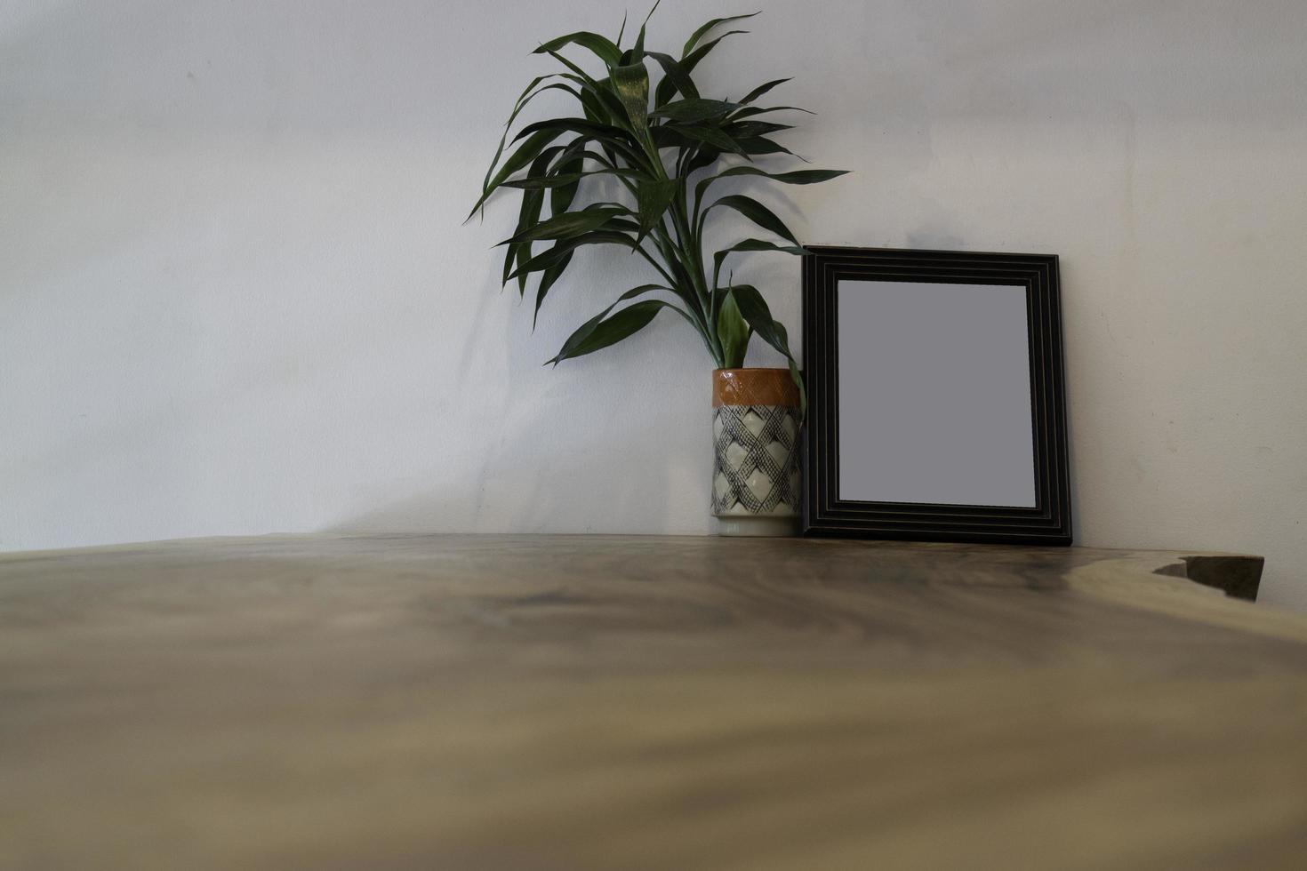 Empty frame mock up with plant on table photo