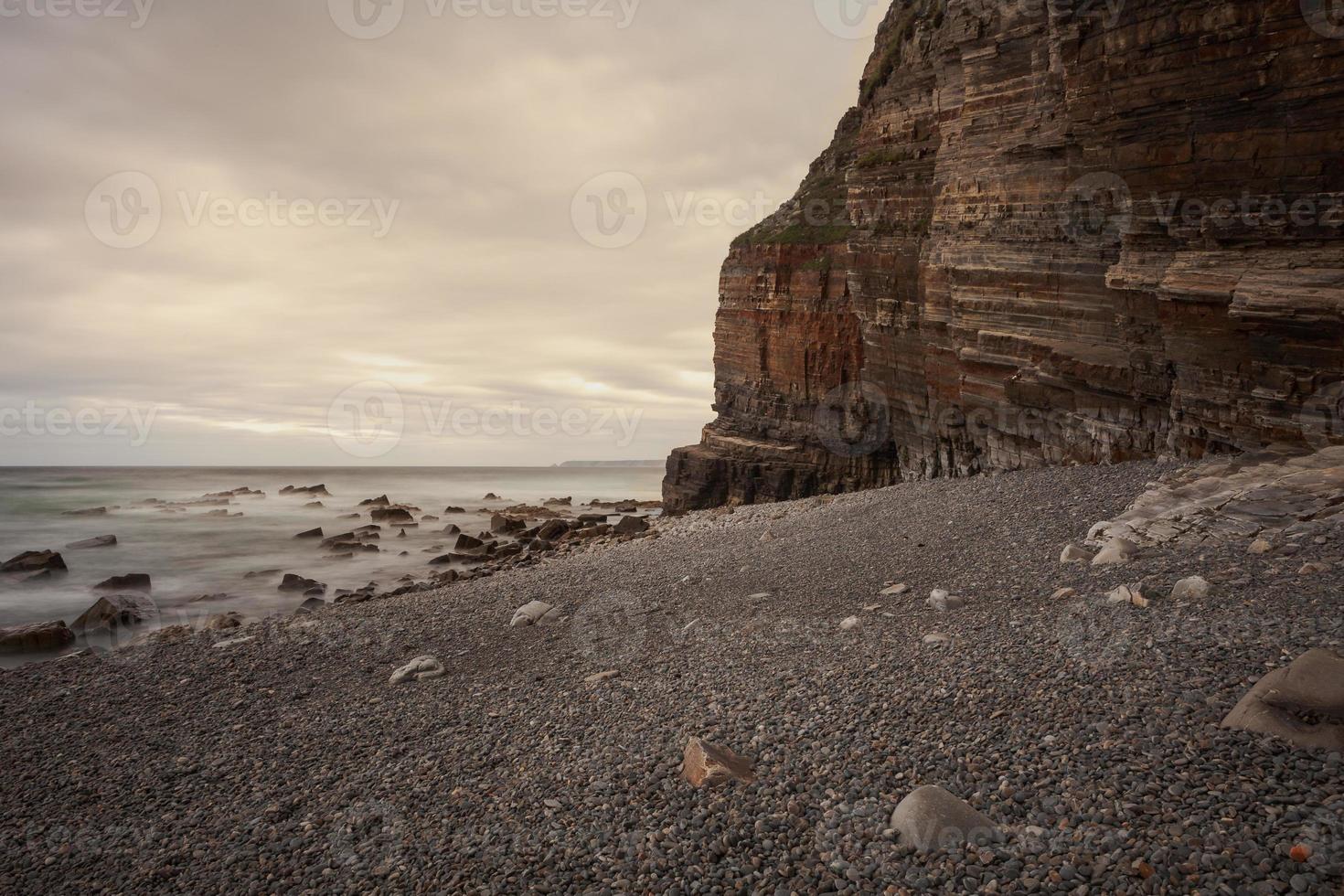 Beach with mountains in the background and warm sunset light photo