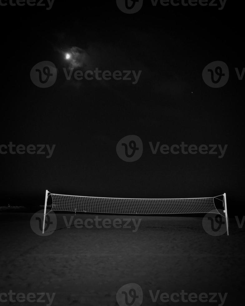 Campo de voleibol solitario en una playa en una noche de luna foto