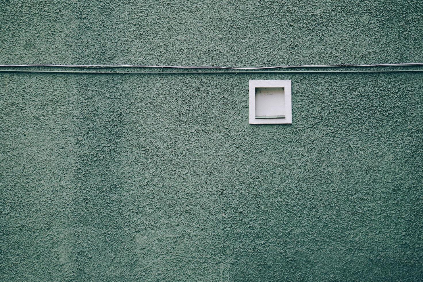 una ventana en la fachada verde del edificio foto